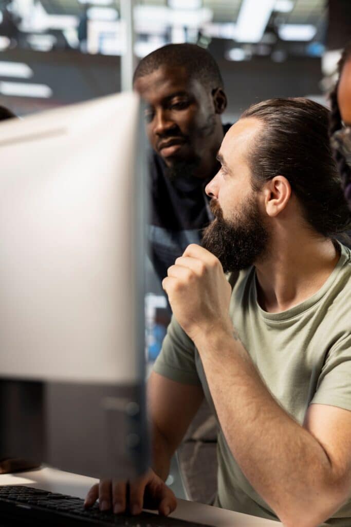 Photo de 2 collaborateur derrière un écran d'ordinateur. Engagement du Groupe Sincrone avec son Académie Simplon